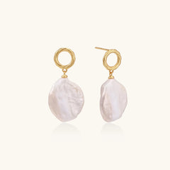 18K gold vermeil twisted circle studs with organic white baroque pearl drops on cream background