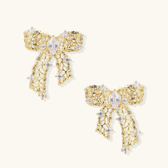 Filigree bow-shaped earrings with marquise center stone and lattice ribbon tails in gold and silver finishes