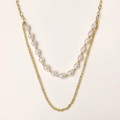 Layered gold chain necklace with organic baroque freshwater pearls and adjustable length on cream background