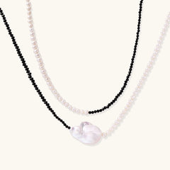 Double-strand necklace with black faceted quartz and white pearls featuring an oversized baroque pearl centerpiece