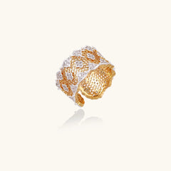Two-tone gold and silver lattice ring with clover pattern and crystal accents on white background