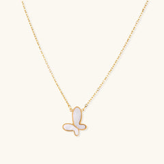 Gold-plated butterfly pendant with iridescent mother of pearl inlay on delicate chain against cream background.